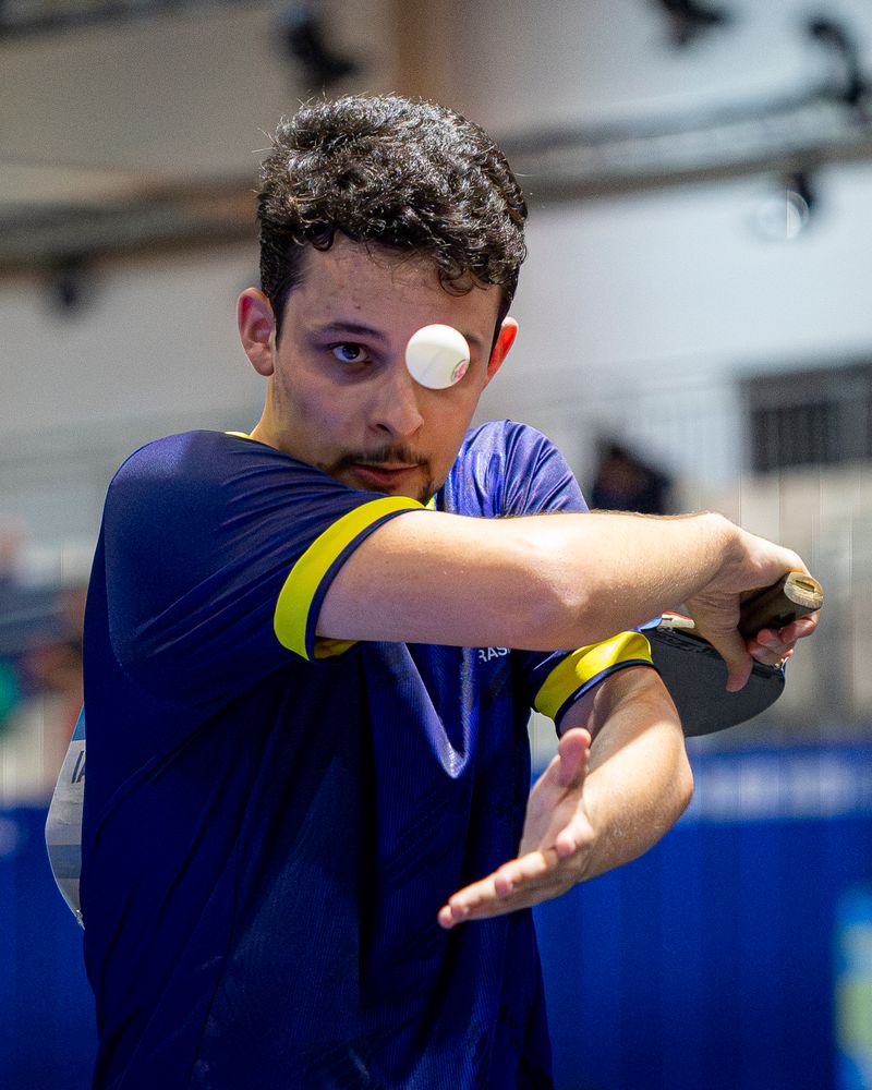 Table tennis player striking the ball mid-match