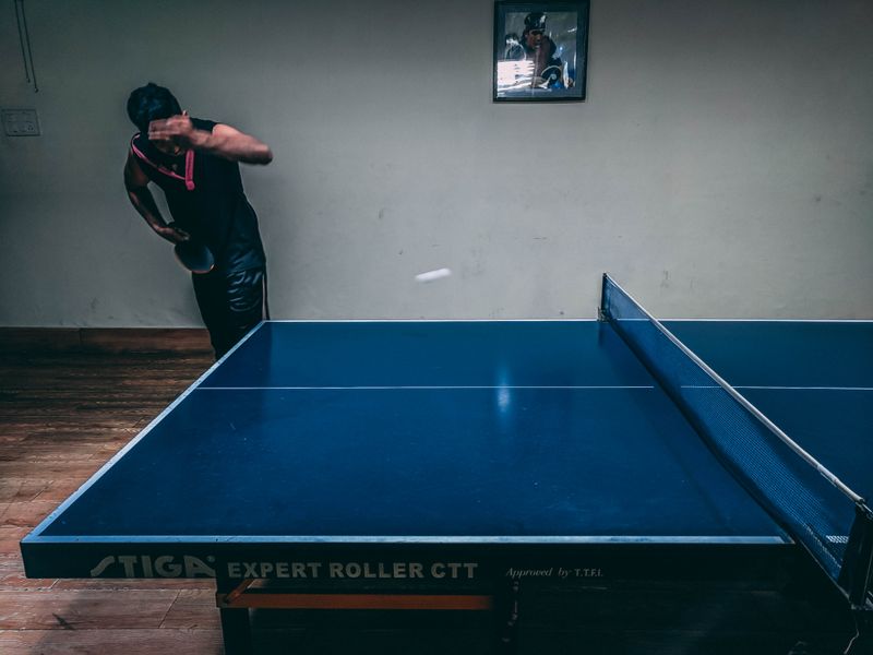 Player practicing table tennis indoors